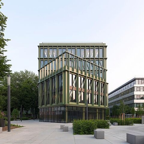 Modern i8-gebouw in München met groene glazen gevels en een begroeid dak, uitgerust met brandbeveiligingsproducten van Wildeboer.