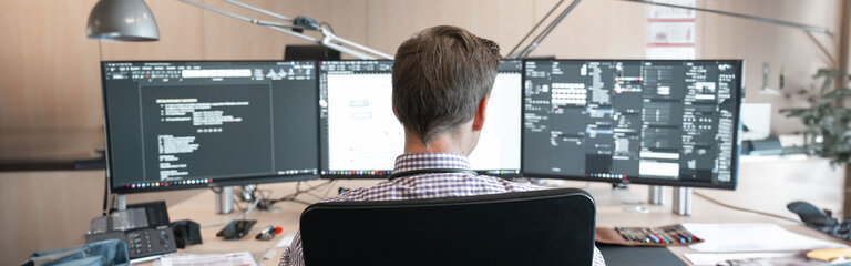 Medewerker aan zijn pc, van achteren gezien